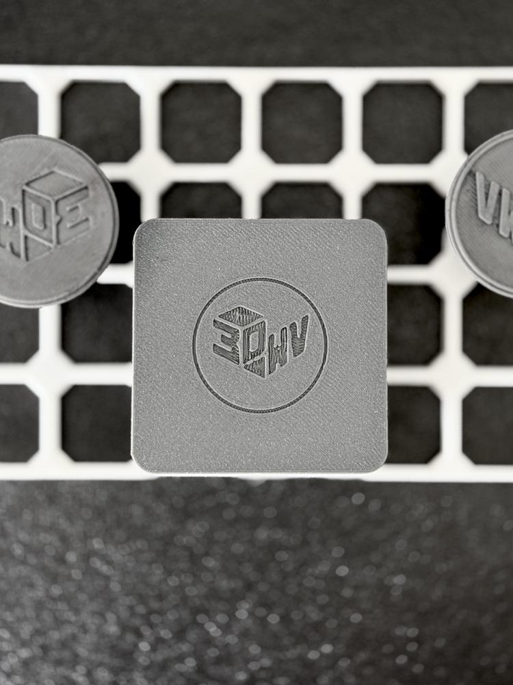 Placca quadrata grigia stampata in 3D con il logo 3D WAY in rilievo